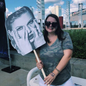 Maggie Kooi holds up a Taylor Swift Poster
