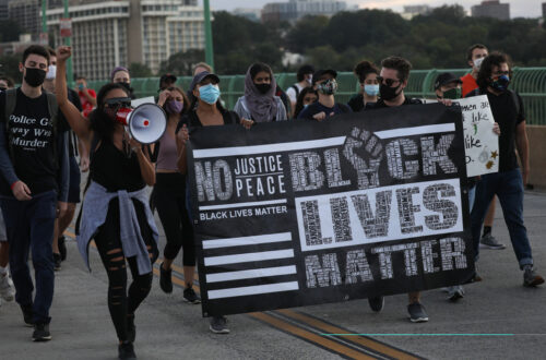 A group of people marching across Key Bridge in Washington D.C. during a BLM Protest