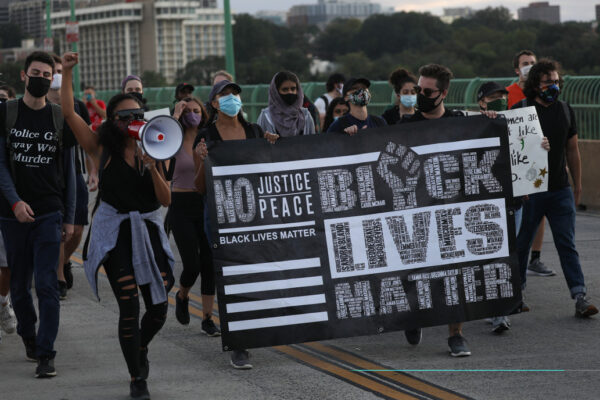 A group of people marching across Key Bridge in Washington D.C. during a BLM Protest